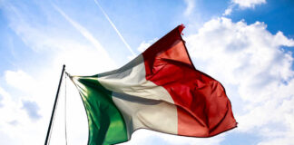 Italian flag waving against a blue sky