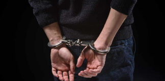 Person's hands cuffed behind their back