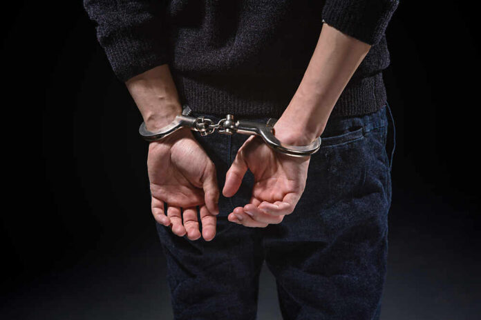 Person's hands cuffed behind their back