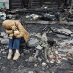 UN Report: Unseen Child War Victims Soar A child sitting on a stone amidst a devastated landscape, holding a teddy bear