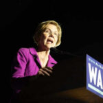 Social Media Rejection: Warren’s Latest Flop Woman speaking at a podium with microphone.