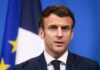 Brigitte Macron’s Viral Slap Sparks New Allegations Man speaking at podium in front of flags