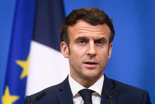 emmanuel-macron2139121517 Man speaking at podium in front of flags