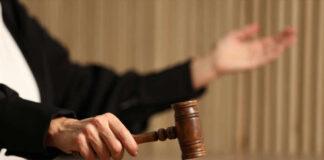 Judge's hand striking a wooden gavel on a block