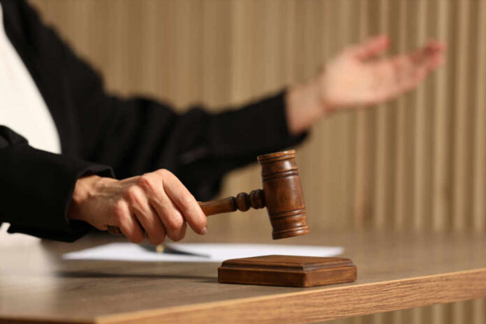 judge-striking-mallet-at-wooden-table2419159367jpg Judge's hand striking a wooden gavel on a block