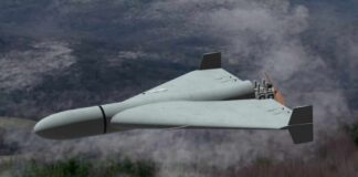 Flying wing drone with pusher propeller over foggy forest