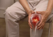 Person holding knee with highlighted joint pain illustration