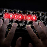 Brooklyn Nets Star TARGETED – How Did This Happen? Hands typing on a backlit keyboard with the word 'DOXXING' illuminated in red