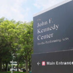 Sign for the John F. Kennedy Center for the Performing Arts with trees in the background