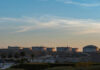 Oil storage tanks against a sunset sky