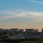 Oil storage tanks against a sunset sky