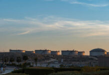 Oil storage tanks against a sunset sky