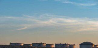 Oil storage tanks against a sunset sky