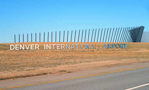 Sign for Denver International Airport against a clear blue sky