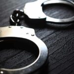 Explosive Arson Plot Unveiled—Class Warfare Fueled It Close-up of metallic handcuffs on a textured surface