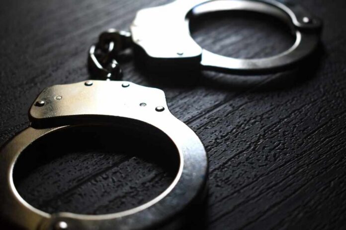shutterstock_2339079889.jpg Close-up of metallic handcuffs on a textured surface