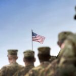 Soldiers standing in formation with an American flag in the background
