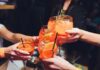 Group of friends toasting with colorful cocktails