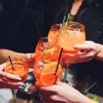 Summer Mode Activated: 16°C Sparks Aperol Craze Group of friends toasting with colorful cocktails