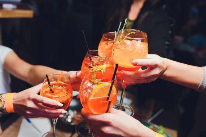 Group of friends toasting with colorful cocktails