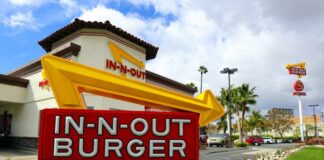 In-N-Out Burger restaurant sign with a bright yellow arrow