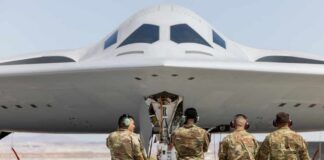 Military personnel inspecting a stealth bomber aircraft
