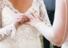 A bride placing a wedding ring on her partner's finger during a ceremony