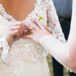 A bride placing a wedding ring on her partner's finger during a ceremony