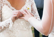 A bride placing a wedding ring on her partner's finger during a ceremony