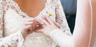 A bride placing a wedding ring on her partner's finger during a ceremony