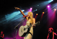 Explosive Plot Against Swift — 15-Year Sentence! Singer with acoustic guitar performing on stage