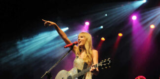Singer with acoustic guitar performing on stage