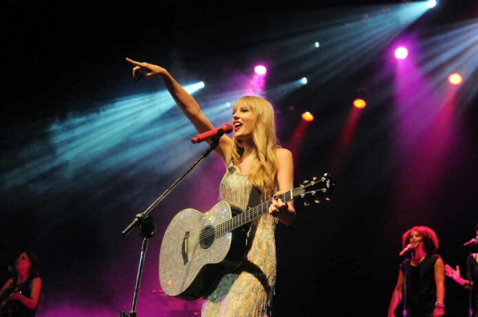 Singer with acoustic guitar performing on stage