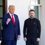Whistleblower WHO? 2019 Mystery Deepens Two men standing outdoors near flags and doorway