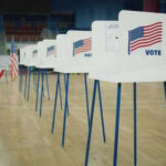 The Next Front In Election Security Voting booths lined up in a gymnasium.