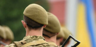 Soldiers in uniform with Ukrainian flag patches.