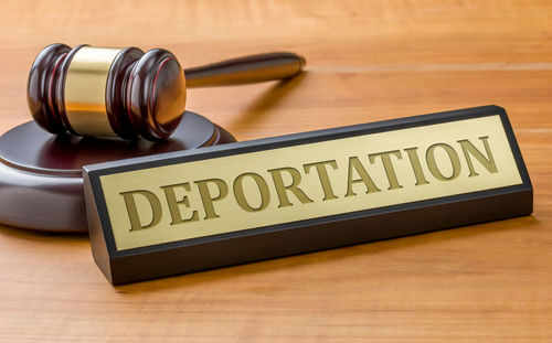 Gavel and sign reading Deportation on desk.