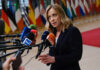 Trump Torches Meloni—Italy Blinks On Iran Woman speaking at a press conference with multiple microphones