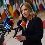 Woman speaking at a press conference with multiple microphones