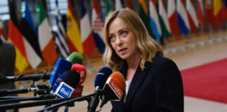 Woman speaking at a press conference with multiple microphones