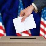 Guilty Plea — Still On The Rolls? Hand placing envelope into ballot box with flag background