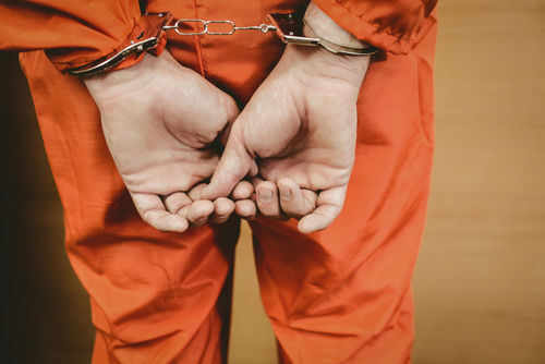 prisoner243760507 Person in orange jumpsuit with handcuffs behind back