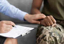 Person comforting someone in military uniform with clipboard