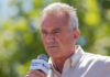 Man speaking into microphone at outdoor event