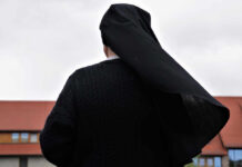 Nuns Challenge State Gender Identity Law A nun in black attire standing outdoors with a cloudy sky in the background