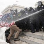 Media Spin Exposed: The Pardon Panic Police in riot gear spray crowd with water on government building steps