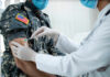 A healthcare professional administering a vaccine to a soldier