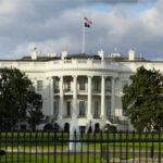 AI Roosevelt Crashes The White House The White House with an American flag flying above it