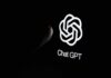 Close-up of a hand reaching towards the ChatGPT logo on a smartphone screen