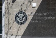 Citizenship Fees Spark New Immigration Debate Signage for U.S. Citizenship and Immigration Services on a building